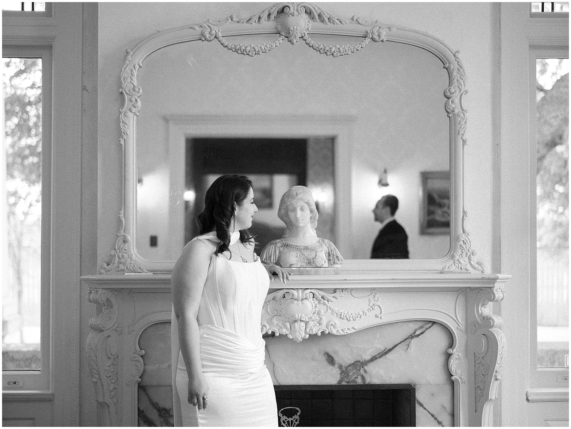 Bride beside the marble fireplace at the Alexander Mansion, black and white