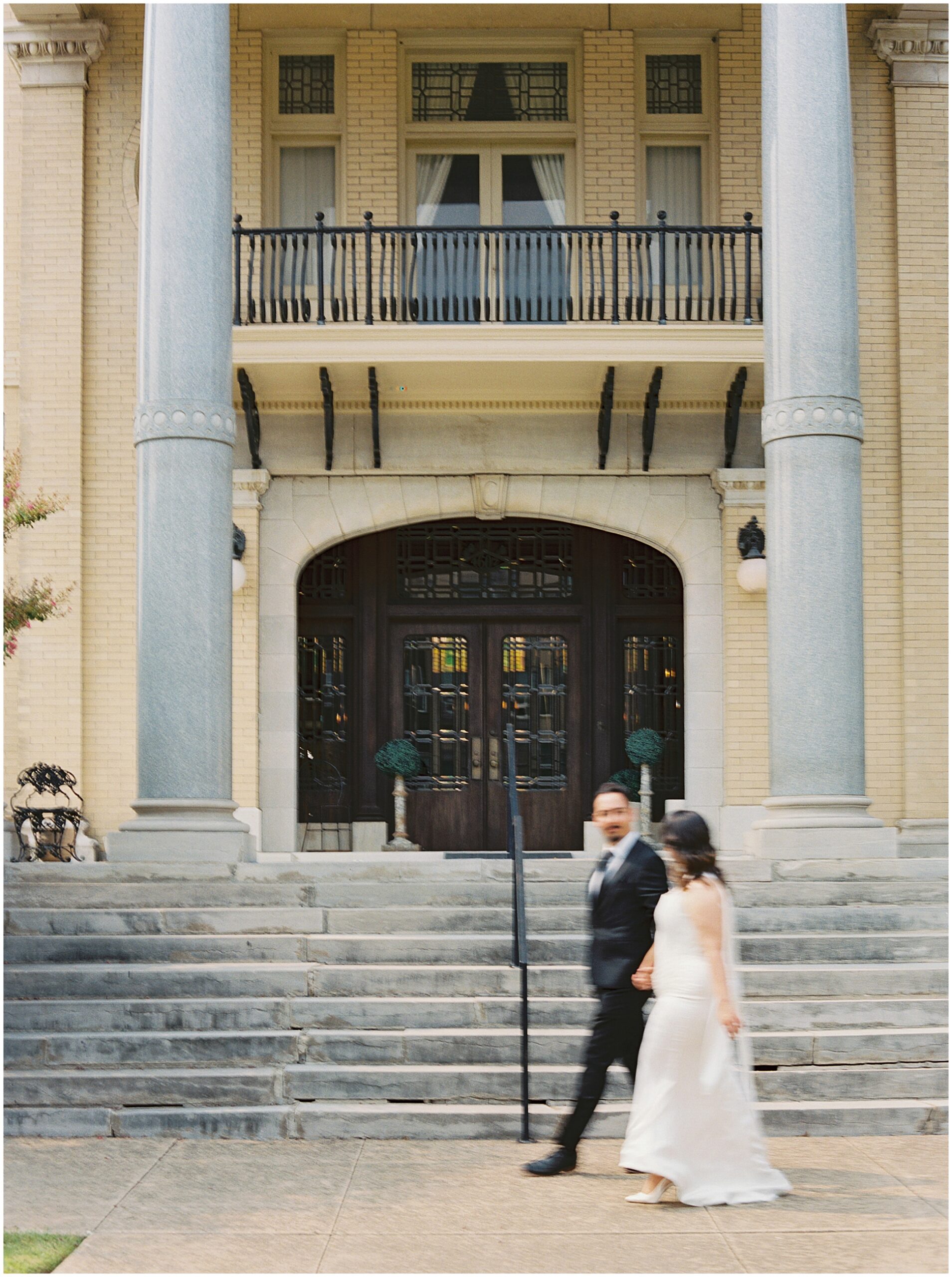 couple walking in front of the Alexander house