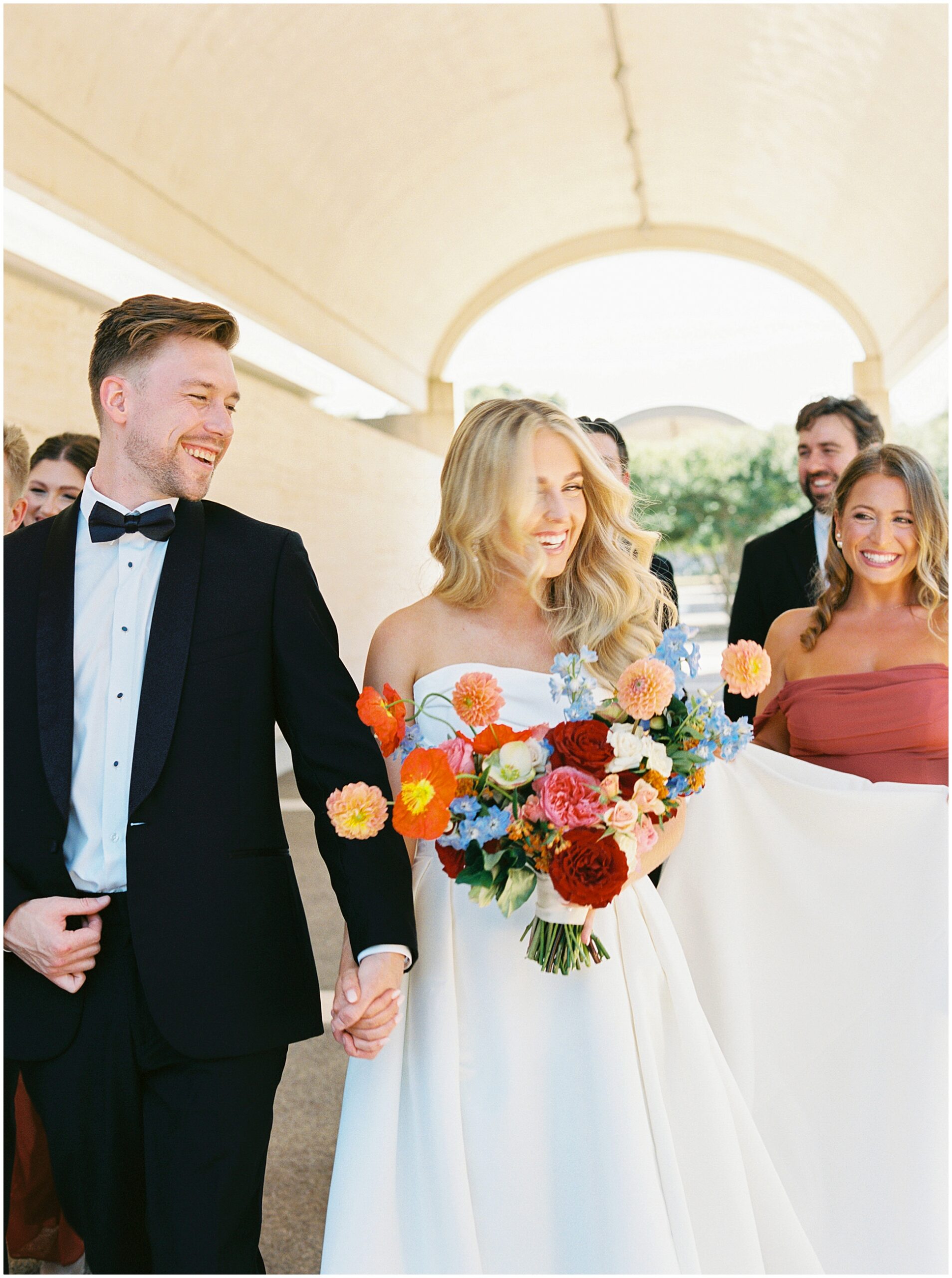 bride and groom walking with their wedding party back to hotel crescent fort worth