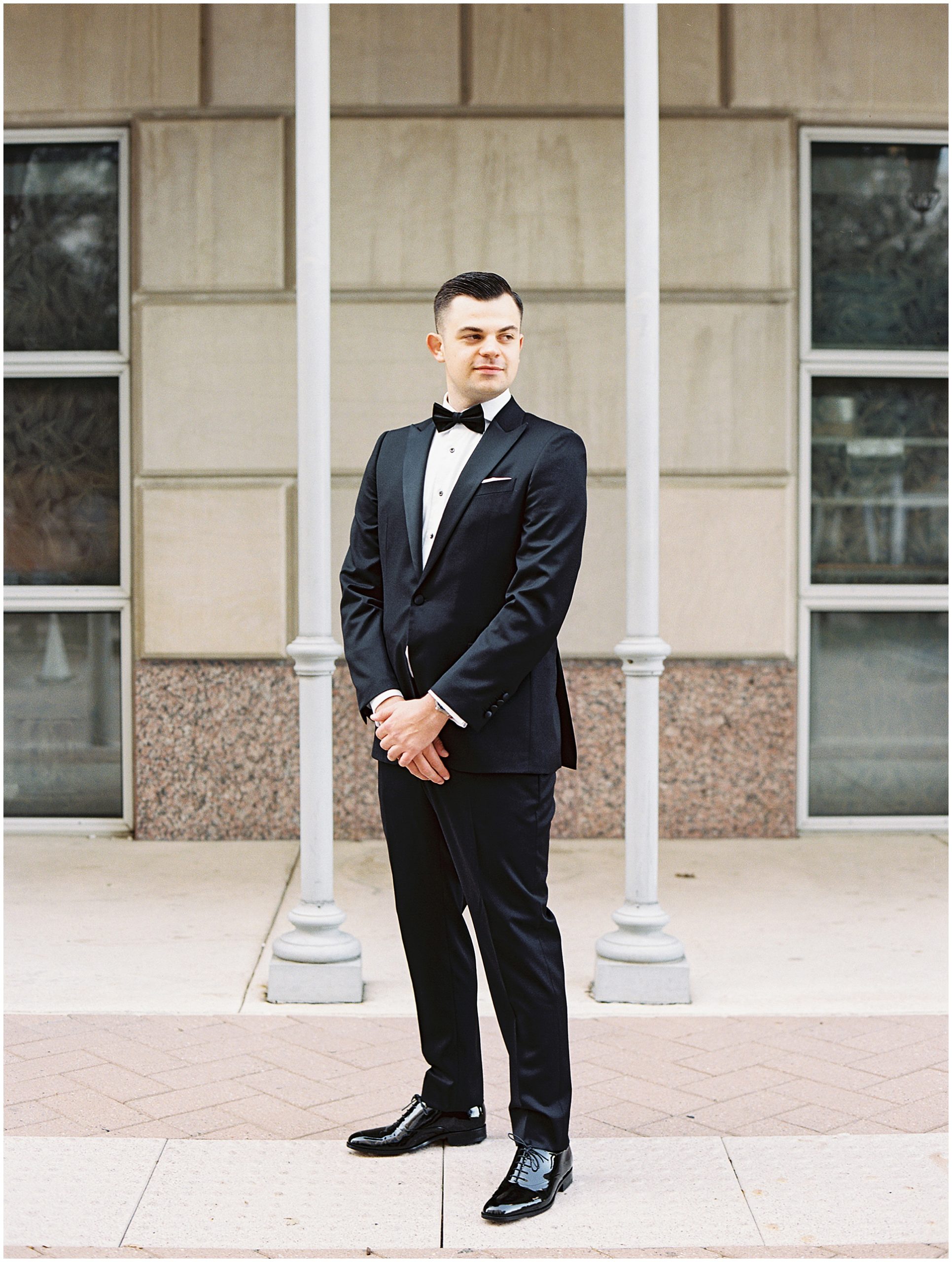 Groom standing outside of Hotel Crescent in Dallas