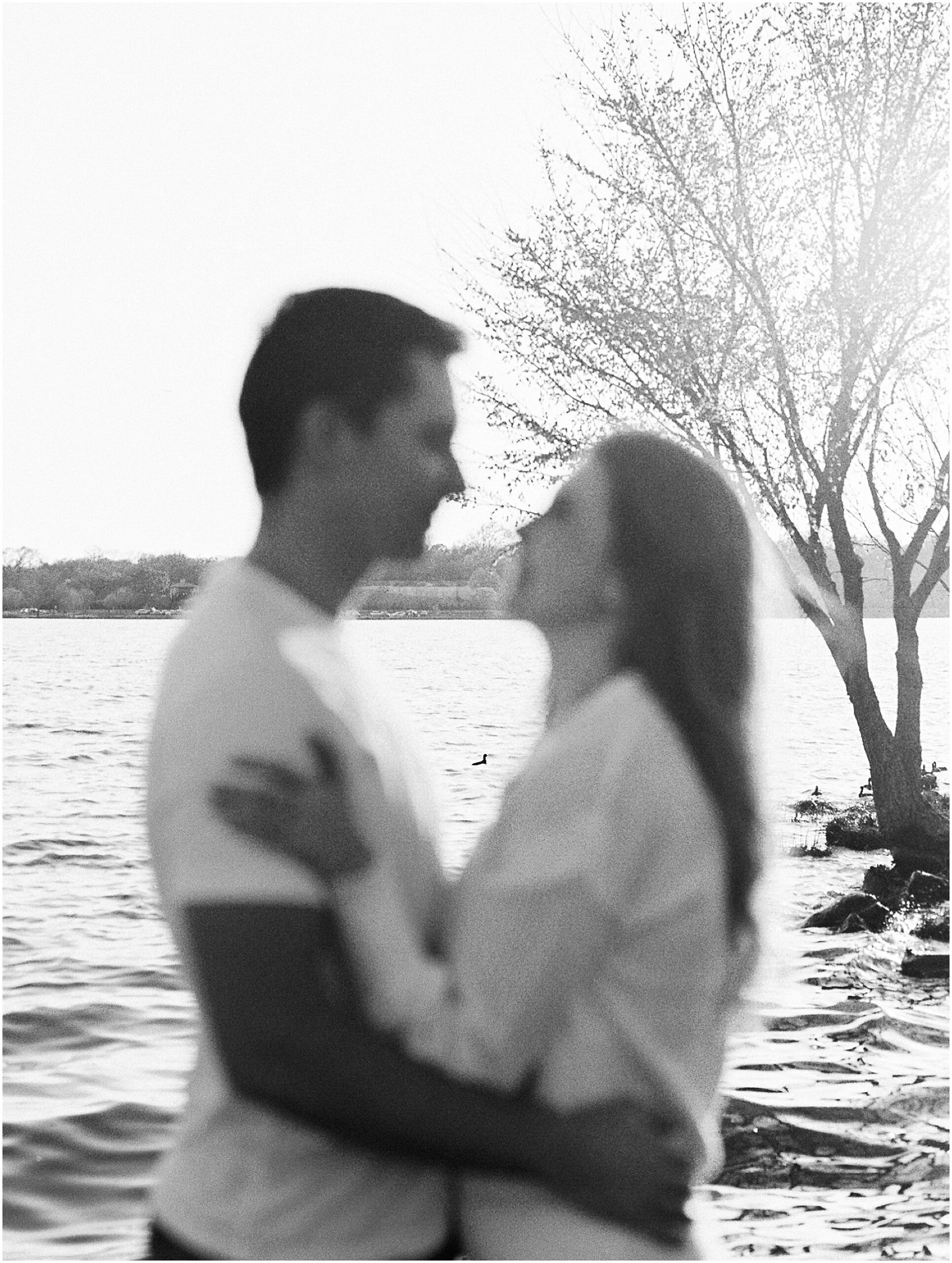 Erin and Zach embracing on a rustic wooden dock at White Rock Lake during their engagement session