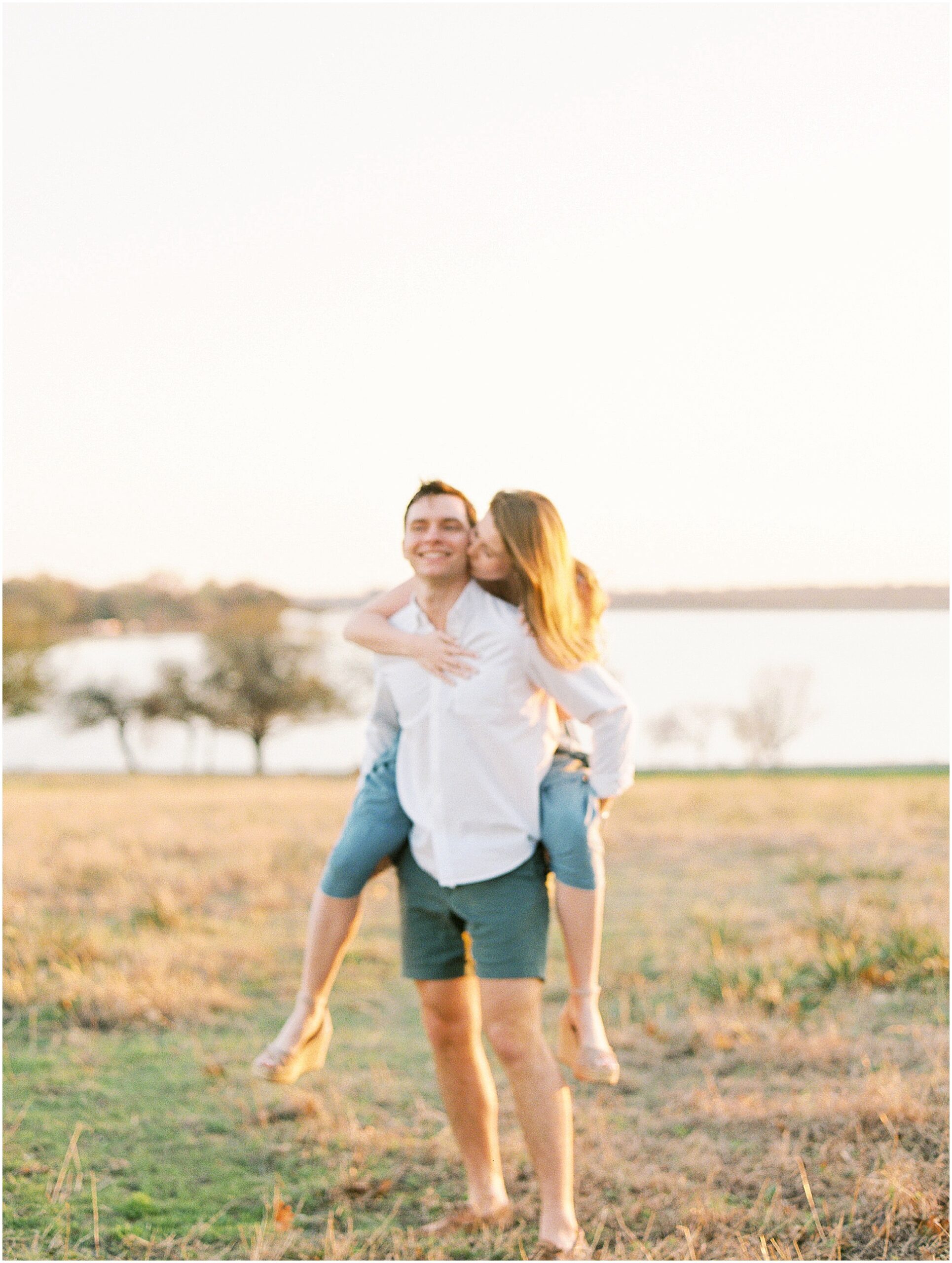 Erin and Zach embracing on a rustic wooden dock at White Rock Lake during their engagement session