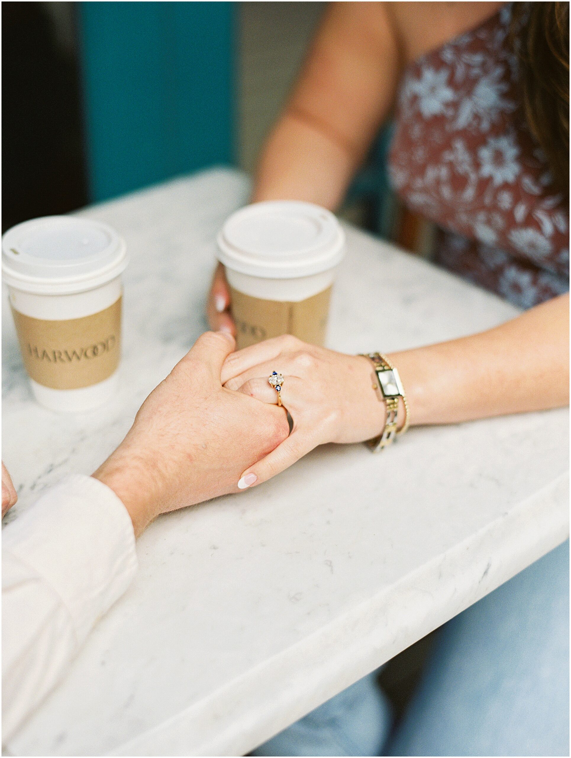 Engaged couple sit and drink coffee for their engagement session 