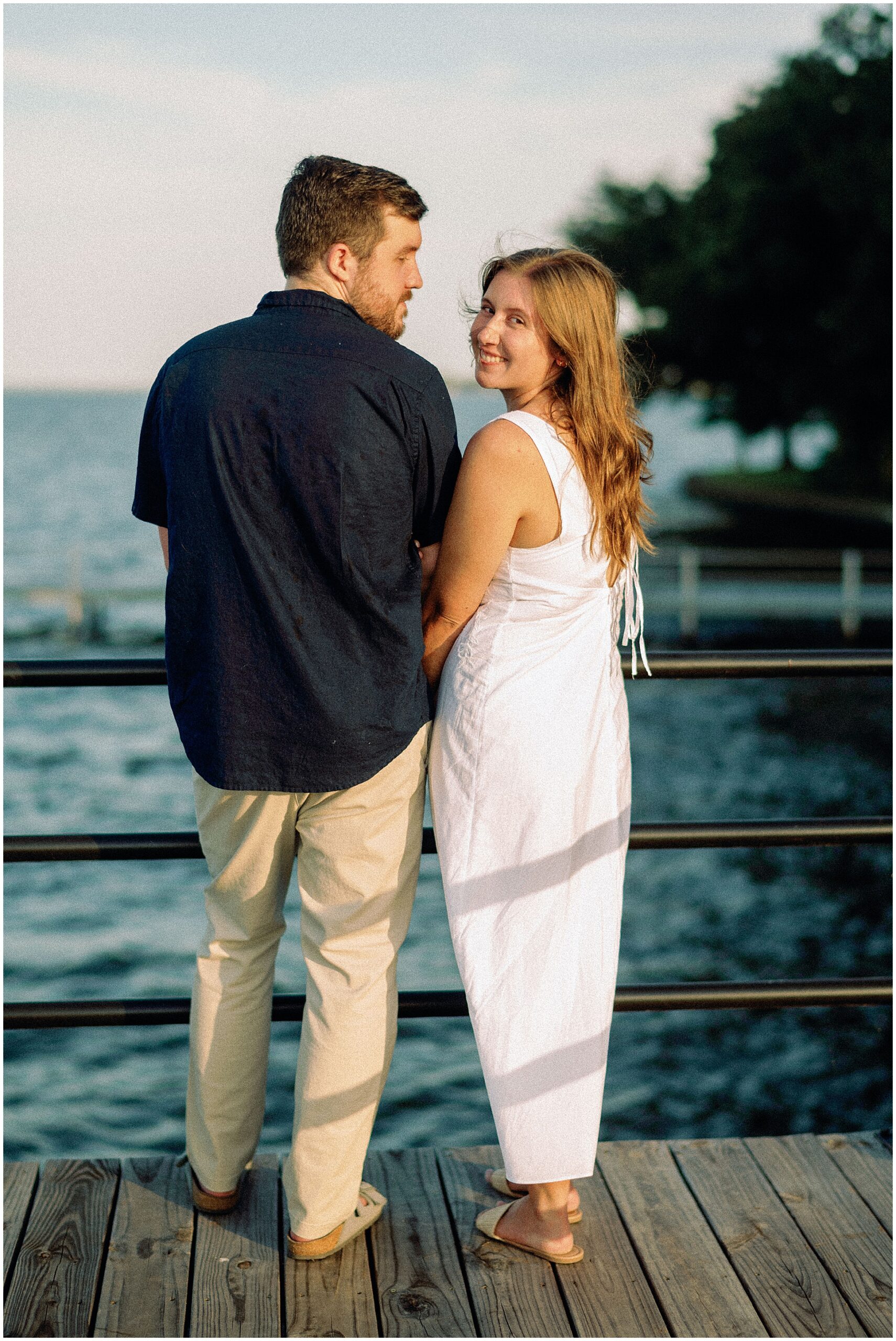 Candid shot of Samantha and Jordan laughing together at the lake house for their engagement session