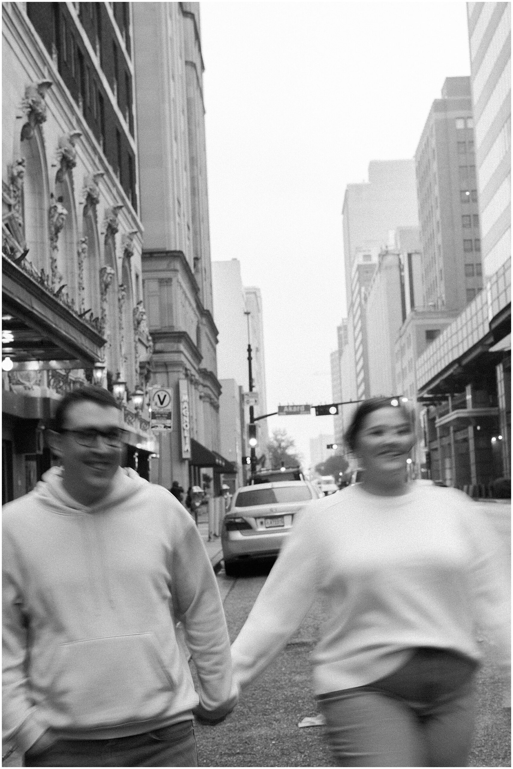 Black and white motion blur of a couple walking down Commerce Street in downtown Dallas during their engagement session